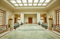 an empty hallway with benches and windows