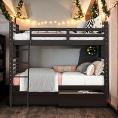 a bunk bed with two sets of drawers underneath it and christmas lights on the wall