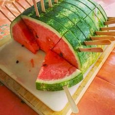 a watermelon cut in half with toothpicks sticking out of the top