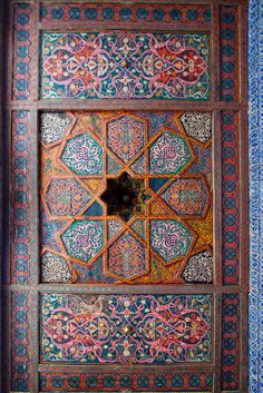 an intricately decorated wooden door in the middle of a building