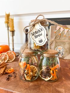 three mason jars filled with dried fruit and spices on top of a wooden cutting board