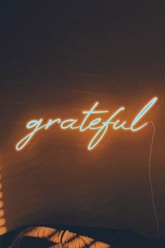 a neon sign that reads grateful on the wall