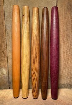 five different types of wooden baseball bats lined up in a row