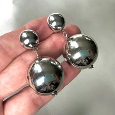 Vintage 80s polished silver tone modernist clip on earrings featuring extra large polished balls suspended from  platinum silver tone domed clips. The diameter of domed clips is 1.2 cm/0.5", the diameter of platinum silver tone beads is 2.5 cm (1") the total length is 5 cm ( 2")  weight 22 grams and they are in excellent vintage condition (NOS from Italy) For more vintage jewellery please visit my Etsy shop: http://vintageviomar.etsy.com SHIPPING UK -Royal Mail Signed For 1st Class (delivery aim Modern Metal Dangle Clip-on Earrings, Modern Dangle Clip-on Earrings For Formal Occasions, Modern Dangle Clip-on Earrings For Evening, Modern Evening Dangle Clip-on Earrings, Modern Evening Clip-on Dangle Earrings, Minimalist Metal Clip-on Earrings For Formal Occasions, Silver Metal Clip-on Earrings For Formal Occasions, Formal Silver Metal Clip-on Earrings, Minimalist Metal Clip-on Earrings For Party