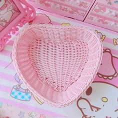 a pink heart shaped basket sitting on top of a table next to a mirror and drawers