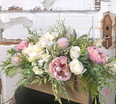 an arrangement of flowers in a wooden box