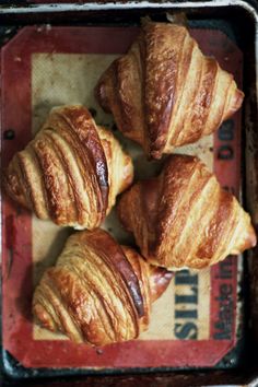 four croissants sitting on top of a red tray