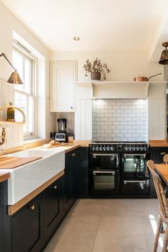 a black and white kitchen with wooden counter tops