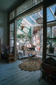 the sun shines through an open window into a room filled with plants and furniture