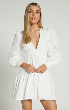 Say hi to the dress of your dreams, our Carlyle Dress! This chic mini has a flattering fitted bodice with corset-style detail, a flared skirt, a deep V-neckline, button detail on the front, and long puff sleeves with cuffs. It makes a great staple in your wardrobe as it can easily be dressed up or down. Wear it to a day party with heeled sandals, a statement necklace and a mini handbag to match! Shop all  Showpo . Product Details Invisible zipper with hook-and-eye on centre back Button closure o Long Sleeve White Dress Casual, White Dresses With Sleeves, White And Cream Outfits, Long Sleeve Corset Dress, Long Sleeve White Dress, White Dress With Sleeves, White Dress Spring, Long Sleeve Corset, White Long Sleeve Mini Dress