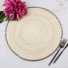 a place setting with pink flowers and silverware