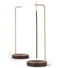 two wooden and metal poles with one standing on the other, in front of a white background