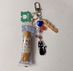 a keychain with a bag of cookies and a cat charm attached to it