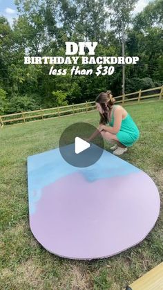 a woman kneeling down on top of a purple and blue surfboard in the grass