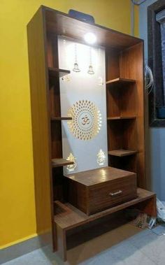 an open bookcase with drawers and lights on the top shelf, next to a window