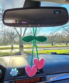 a car dashboard with two pink hearts hanging from the dash