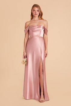 a woman in a long pink dress with an off the shoulder top and thigh slit