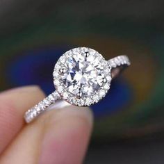 a person holding a diamond ring in their hand