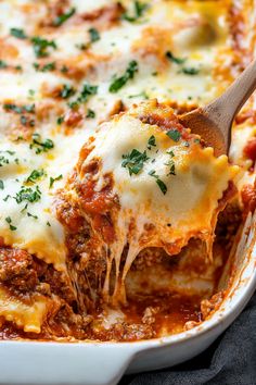 a casserole dish with meat and cheese being lifted from the casserole