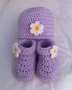 a pair of crocheted baby shoes with flowers on them