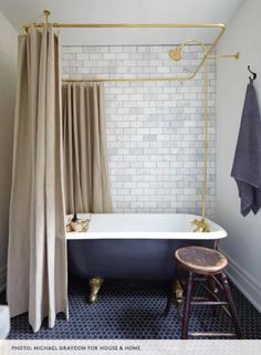 a bathroom with a bathtub, stool and shower curtain