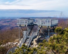 the stairs lead up to an observation platform at the top of a mountain with trees