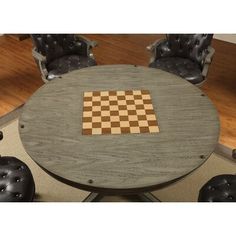 a chess board is placed on top of a round table with four chairs around it