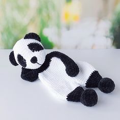 a crocheted panda bear laying on top of a table