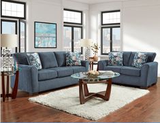 a living room with two couches and a coffee table in front of large windows