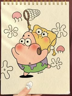 a drawing of a cartoon character is being held up by someone's hand while they are