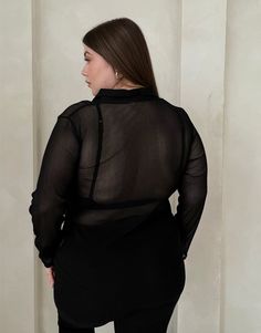 With its sleek and flattering silhouette, the Plus Size Sheer Ribbed Button Up Shirt offers a trending way update to your workwear wardrobe. Wear this plus size sheer top with a cute bralette underneath to give the full effect and a pair of trousers for a street style outfit that's very on trend right now. This top features buttons up the front, long sleeves, a v-shaped neckline, a folded-down collar, and a single chest pocket. The material is a sheer, stretchy knit material. This shirt is made Workwear Wardrobe, Sheer Top, Street Style Outfit, Knitting Materials, Button Up Shirt, V Shape, Chest Pocket, Bralette, Leather Skirt