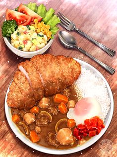 a plate with meat, rice and vegetables on it next to a bowl of salad