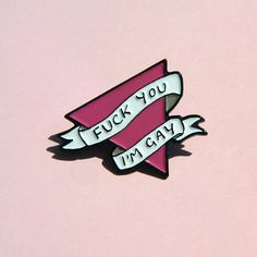 a pink and white pin with the words f k you i'm gay on it