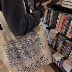 a person carrying a tote bag in front of a book shelf filled with books