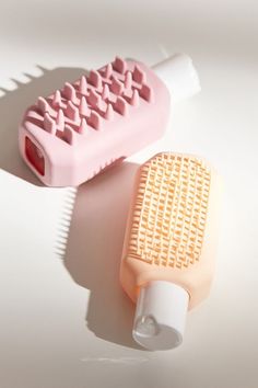 a pink and white brush sitting next to each other on top of a countertop