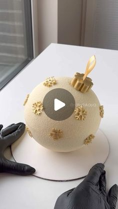 a video demonstrating how to decorate a round cake with gold snowflakes on it