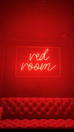 a red room with a couch and neon sign on the wall that says red moon