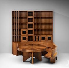 a wooden table sitting in front of a book shelf