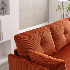 an orange couch sitting in front of a white wall