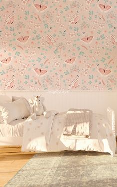 a bedroom with pink wallpaper and white bedding