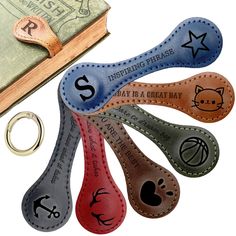 leather key fobrings with different designs on them next to an open book