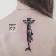 a woman with a tattoo on her back has an orca whale in it's body