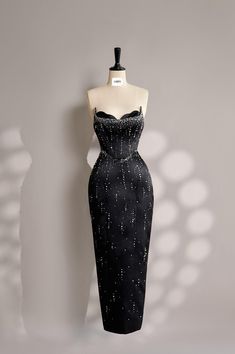 a mannequin wearing a black dress with silver dots on it's chest