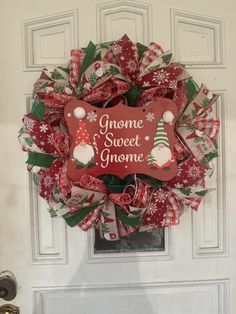 a christmas wreath with gnomes and snowflakes on it hanging from the front door