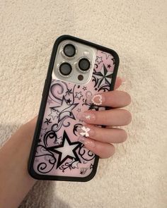 a woman's hand holding an iphone case with stars and swirls on it