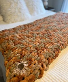 an orange and brown blanket on top of a bed