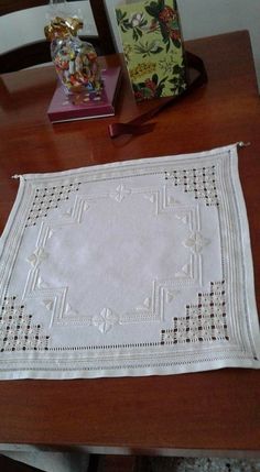 a table with a white doily on top of it next to a small box