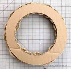 a cardboard circle with rope around it on top of a piece of paper next to scissors