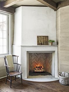 a fireplace with candles in it and a chair next to it