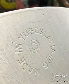 closeup of the bottom of a white vase with writing on it's side